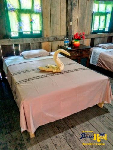 um cisne empalhado numa cama num quarto em Parador Real cabañas 