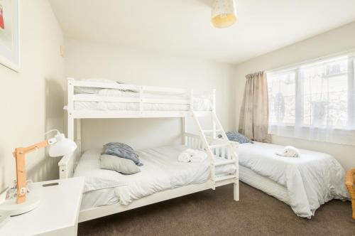 1 Schlafzimmer mit 2 Etagenbetten und einem Fenster in der Unterkunft Lavaud Delight - Akaroa Holiday Home in Akaroa