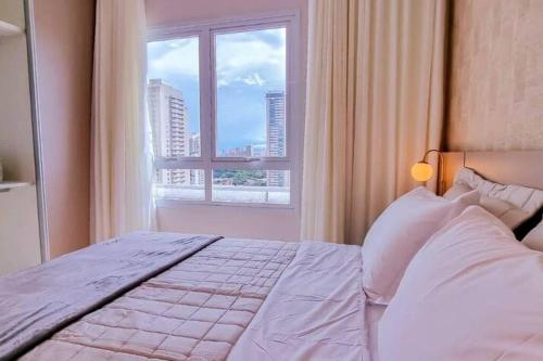a bedroom with a bed and a large window at Blend Smart Marista 2 Quartos in Goiânia