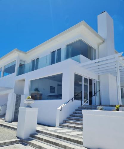 a white house with stairs in front of it at 19 ocean villas in Yzerfontein