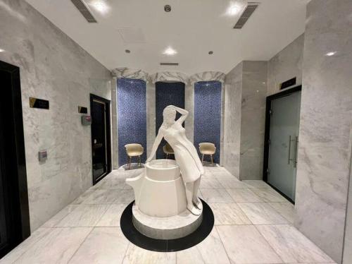 uma casa de banho com uma escultura de uma mulher sentada numa banheira em Serenity SPA ALL-IN apartment Luxury resort private beach em Alanya