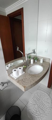 a bathroom counter with a sink and a mirror at Vista incrível na melhor localização da praia da costa in Vila Velha