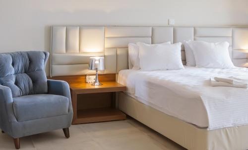 a bedroom with a bed and a blue chair at Electra Hotel in Stavros