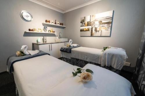 um quarto de hospital com duas camas e um relógio na parede em Fairways resort 6 sleeper unit em Drakensberg Garden