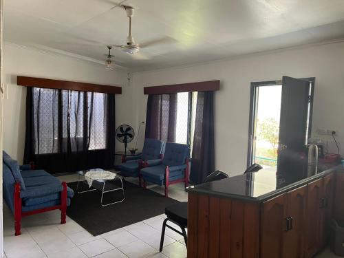 a living room with blue furniture and windows at Ziara Apartments in Nadi