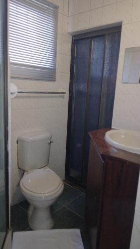 a bathroom with a toilet and a sink at Hamba Kancane Ma-Africa Guest House in Graskop