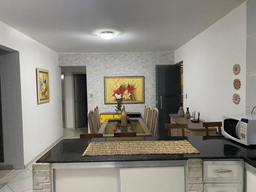 a kitchen and dining room with a table and a microwave at Apartamento grande 900m do centro in Diamantina