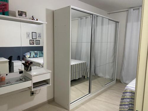a bedroom with a large glass closet with a bed at Apartamento grande 900m do centro in Diamantina