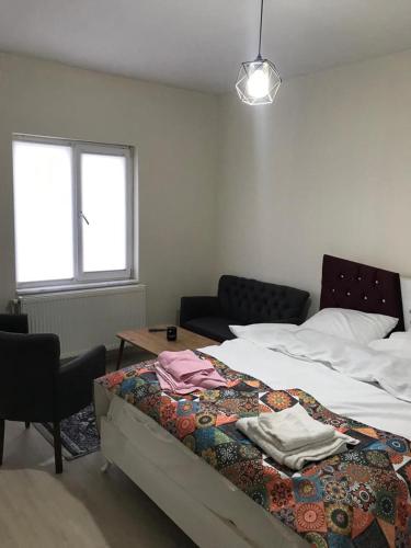 a bedroom with a bed and a couch and a table at Periliköşk Rezidans in Talas