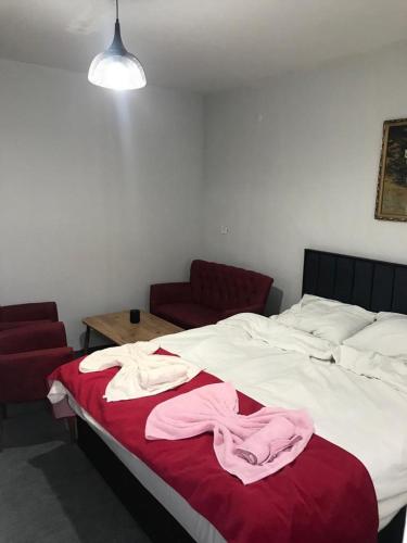 a bed with white sheets and pink towels on it at Periliköşk Rezidans in Talas