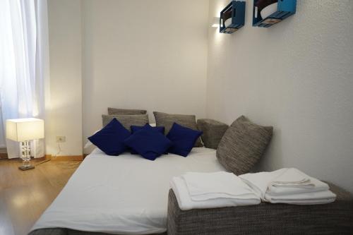 a couch with blue pillows in a room at B&S Suite Colosseo in Rome