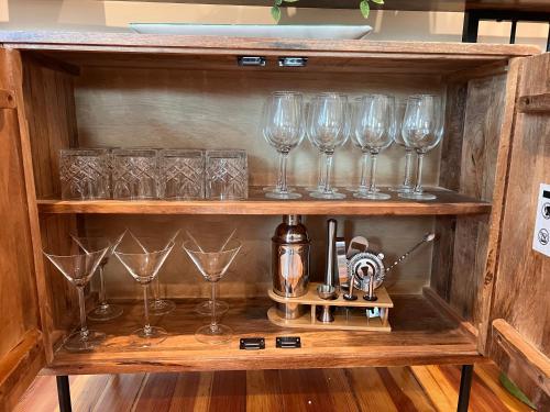 a row of wine glasses sitting on a shelf at Your Boston Retreat - Great porches - 2/BR sleep 6 in Everett