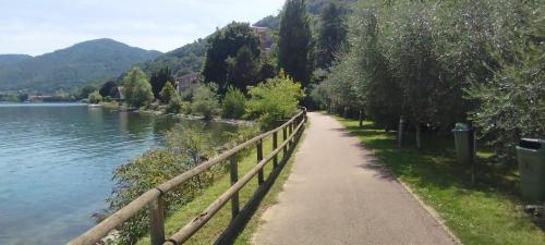 a path next to a river next to a fence at Vista lago Lecco - Neiade Guest house in Pescate
