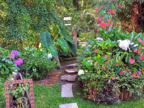 a garden with colorful flowers and a pathway at Recanto dos Jasmins Gramado in Gramado