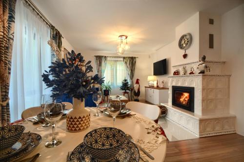 a dining room with a table and a fireplace at Dom w Milówce - Apartamenty na Kowolu in Milówka