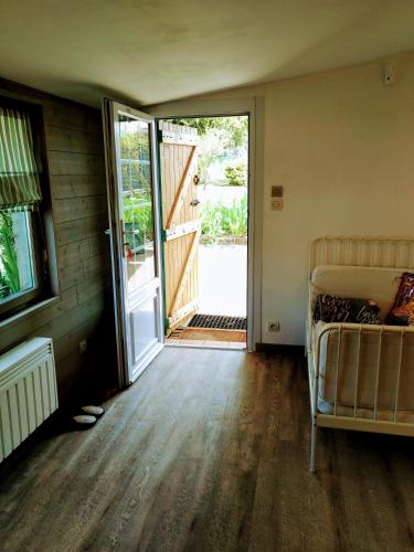 une pièce vide avec un lit et une porte coulissante en verre dans l'établissement Rosemary Cottage, à Sergines