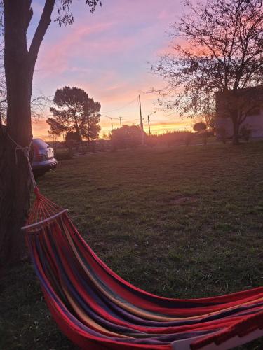 a hammock in a field with a sunset in the background at Casa Sueños Tandil in Tandil