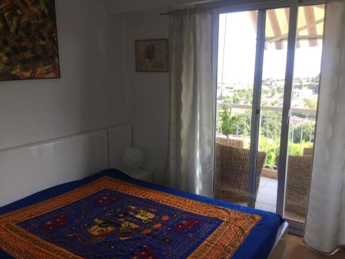 - une chambre avec un lit et un tapis dans l'établissement Les Argonautes, à Villeneuve-Loubet