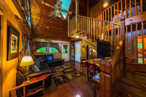 una sala de estar con una escalera en una cabaña en Bear Creek Lodge and Cabins in Helen Ga - Pet Friendly, River On Property, Walking Distance to downtown Helen en Helen