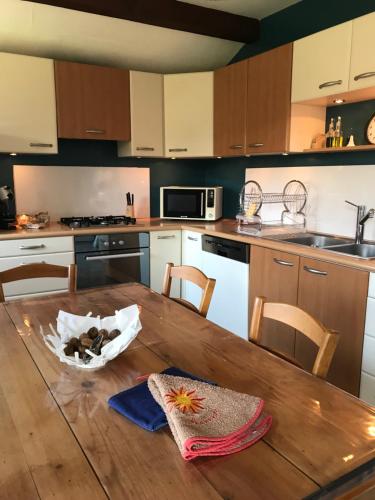 una cocina con una mesa de madera con una bolsa. en Appartement dans maison, en Brié-et-Angonnes