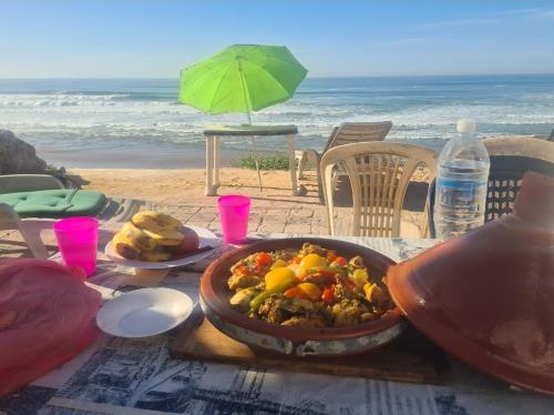 a table with a bowl of food on the beach at Grotte au bord de mer in Tiznit