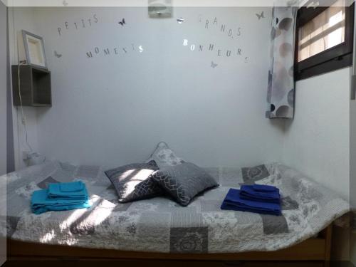 a bedroom with a bed with two pillows and words on the wall at Hameau du Rivage 224 - Rez de jardin climatisé - 3 étoiles - 6 Pers - Jardin - Piscine - Vélos prêtés - Parking - 400m de la plage de La Lagune - WIFI in Saint-Cyprien