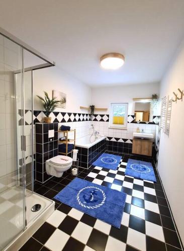 a bathroom with a black and white checkered floor at Familientraum auf 120 m2 in Rostock in Rostock