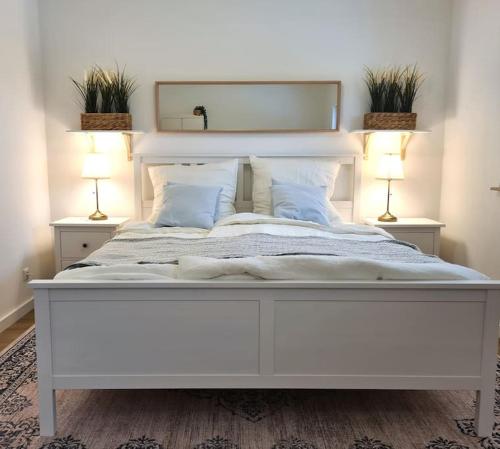 duże białe łóżko w sypialni z 2 lampami w obiekcie Familientraum auf 120 m2 in Rostock w mieście Rostock
