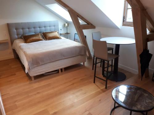 a bedroom with a bed and a table in a attic at Parlement - Beau Studio in Rennes