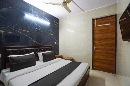 a bedroom with a bed and a wooden door at Super Collection O Hotel SPS in Ghaziabad