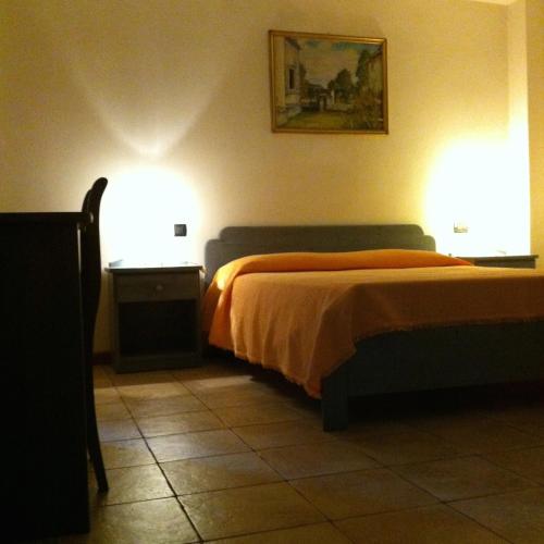 a bedroom with a bed with two lights on it at RosArancio in Bassano del Grappa