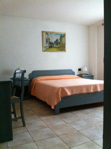 a bedroom with a bed and a picture on the wall at RosArancio in Bassano del Grappa