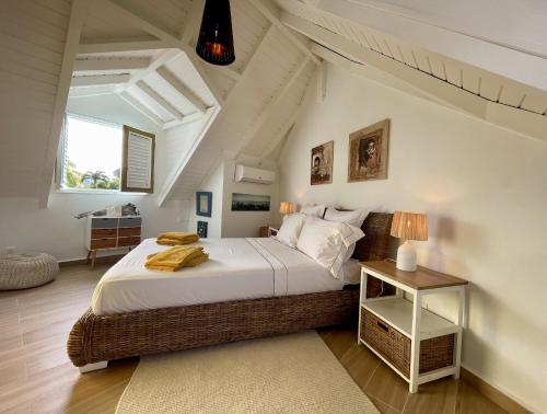 Villa Tilanga في سانت فرانسوا: غرفة نوم بسرير وطاولة مع مصباح