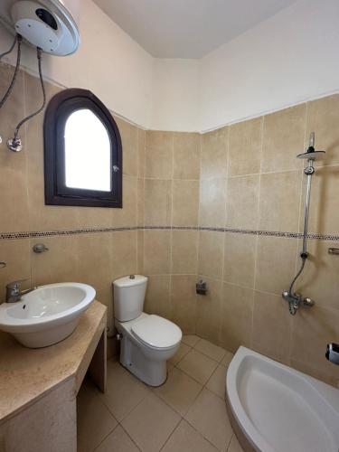 a bathroom with a toilet and a sink and a tub at El Salam hotel in Dahab