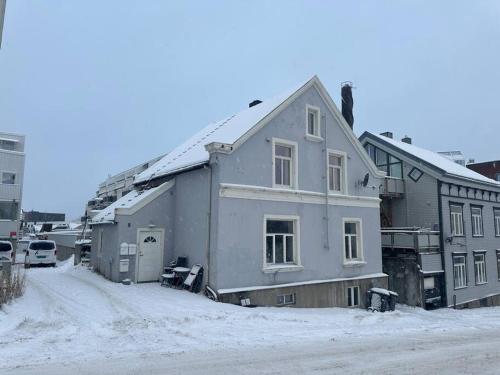 een huis op een straat met sneeuw op de grond bij I hjertet av Nordens Paris. in Tromsø