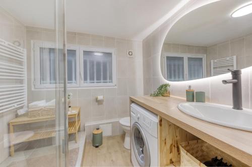 ein Badezimmer mit einem Waschbecken und einer Waschmaschine in der Unterkunft Le ciné cocon - Serenito Homes in Les Pavillons-sous-Bois