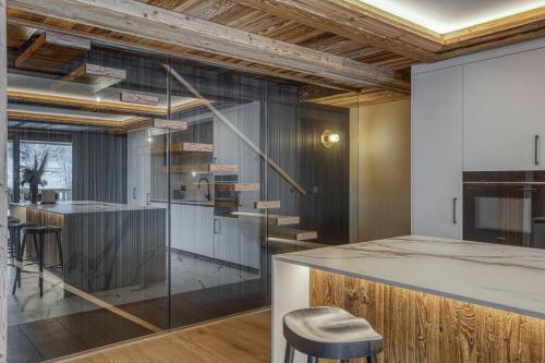 una cocina con barra y un bar con taburetes en Les Chalets de La Clusaz - Appartement Le Faon, en La Clusaz