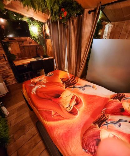 - une chambre avec un grand lit orné d'un tableau dans l'établissement INDIANA JONES à 10 minutes du Parc Disneyland (taille chambre), à Condé-Sainte-Libiaire