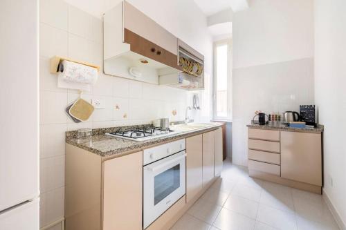 een witte keuken met een fornuis en een wastafel bij Casa amoR in Trastevere in Rome