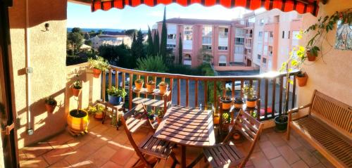 d'un balcon avec une table, des chaises et des plantes en pot. dans l'établissement Le Ciel Bleu - vue mer, toute à pied plage et commerce, à Fréjus
