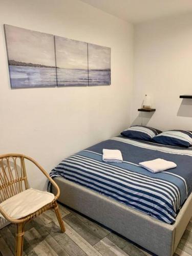 - un lit dans une chambre avec une chaise et une photo dans l'établissement Le Havre 2 Paix, au Havre