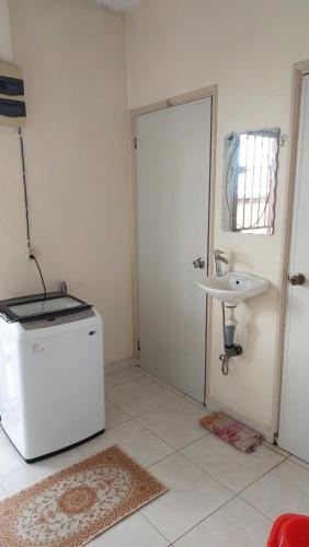 baño pequeño con fregadero y nevera en Apartment Julia, en Paramaribo