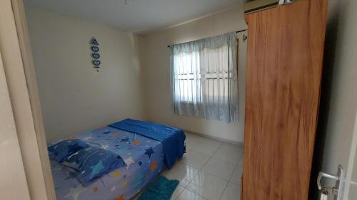 Habitación pequeña con cama y ventana en Apartment Julia en Paramaribo