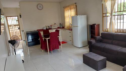 cocina con nevera, mesa y sofá en Apartment Julia en Paramaribo