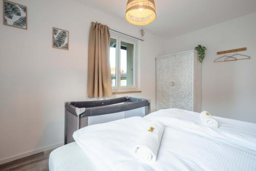a bedroom with two beds and a sink and a window at Moderne Wohnung mit Parkplatz - Top Floor in Ostermundigen