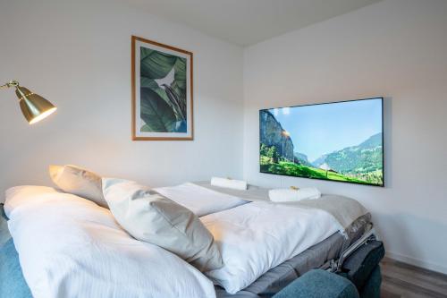 a room with a white couch with a tv on the wall at Moderne Wohnung mit Parkplatz - Top Floor in Ostermundigen