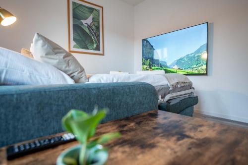 a living room with a couch and a tv at Moderne Wohnung mit Parkplatz - Top Floor in Ostermundigen