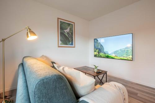 a living room with a blue couch and a table at Moderne Wohnung mit Parkplatz - Top Floor in Ostermundigen