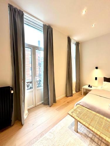 a bedroom with a bed and a large window at My Haus European Commision in Brussels