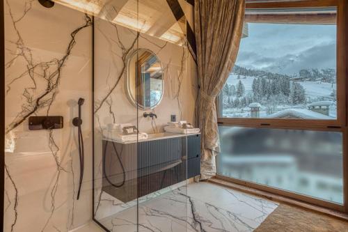 a bathroom with a sink and a mirror and a window at Les Chalets de La Clusaz - Appartement le Renne in La Clusaz